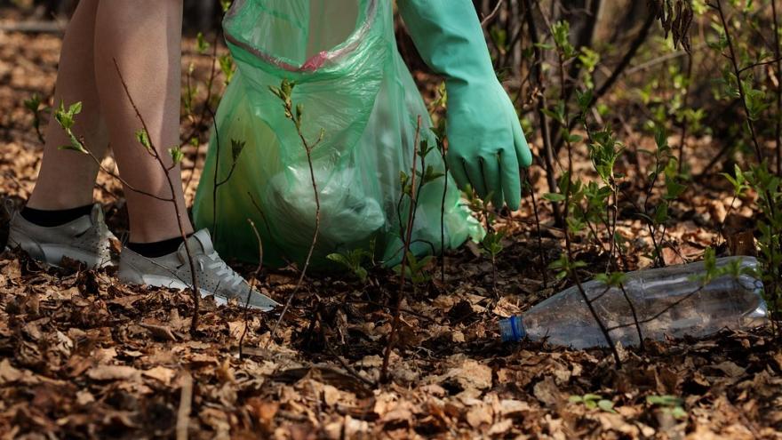Una chica recogiendo basura del parque