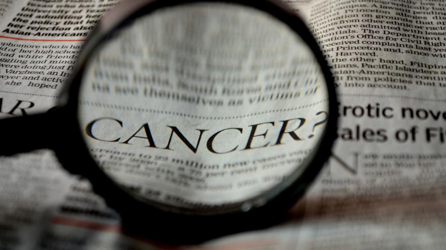 lupa aumentando la palabra "cáncer" en un periódico
