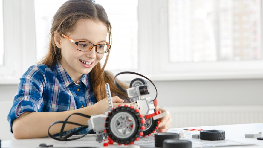 Chica construyendo un robot