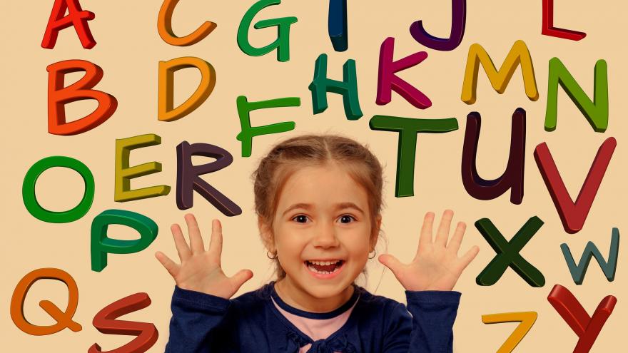niña sonriendo rodeada de letras