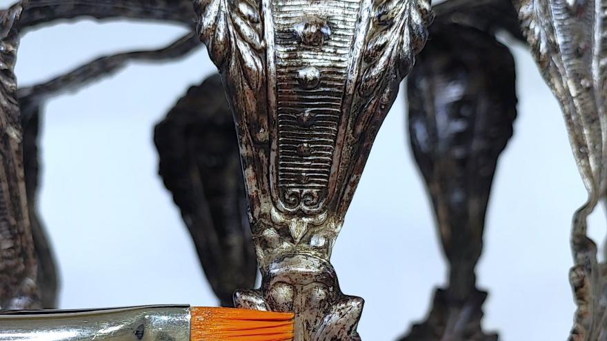 imagen de un pincel sobre una corona de plata decorada