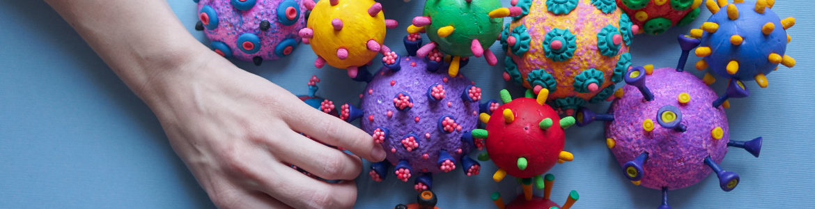 virus del covid en modelos 3D de colores al lado de una mano