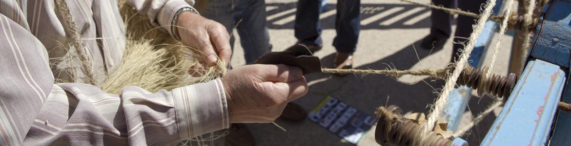 un grupo de hombres en una demostración de hilado de esparto