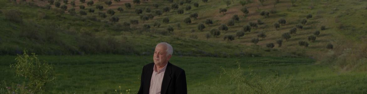 Hombre mayor sentado en un prado verde