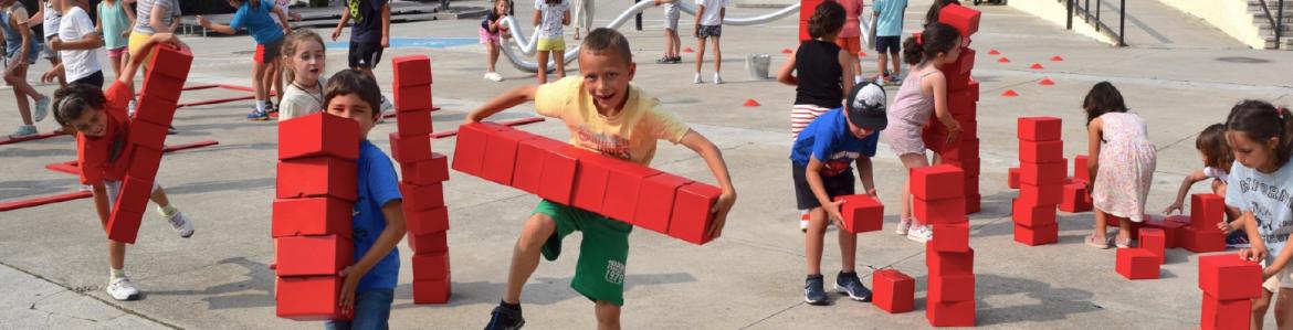 123 Performance con la artista Elisa Miravalles Niños y niñas jugando en una plaza con grandes cubos de color rojo