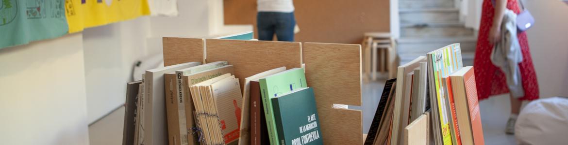 Sala de exposiciones con una estancia llena de libros y paneles con recursos educativos