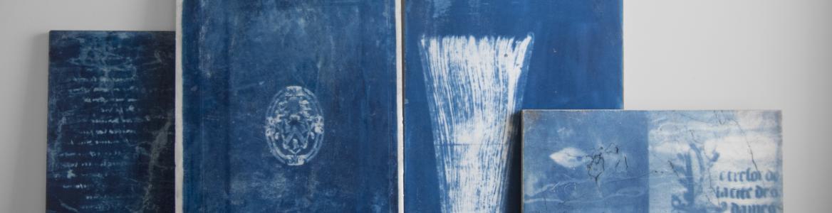 Lienzos azules con dibujos abstractos apoyados en el suelo