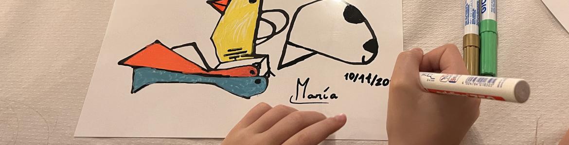 Las manos de una niña pintando sobre una mesa