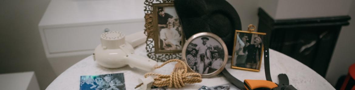 Mesa camilla con fotografías antiguas desordenadas sobre ella