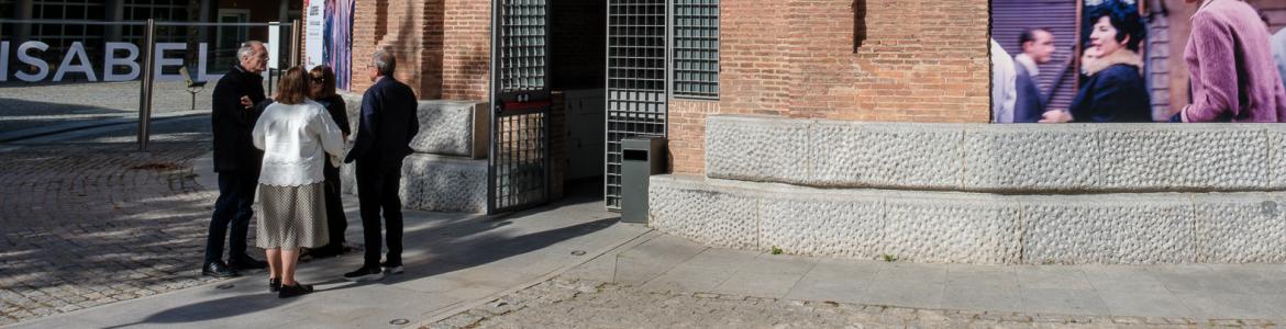 Grupo de personas entrando en un edificio de ladrillo