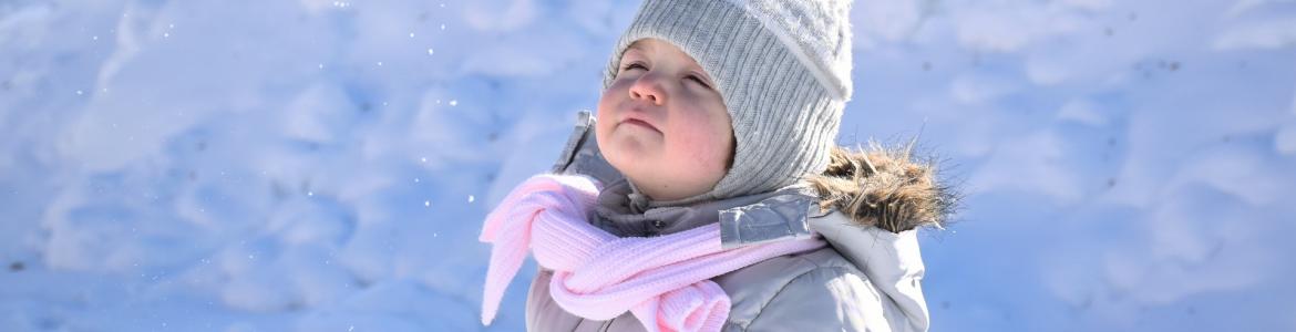 Sarampión Niño con gorro de pie en la nieve