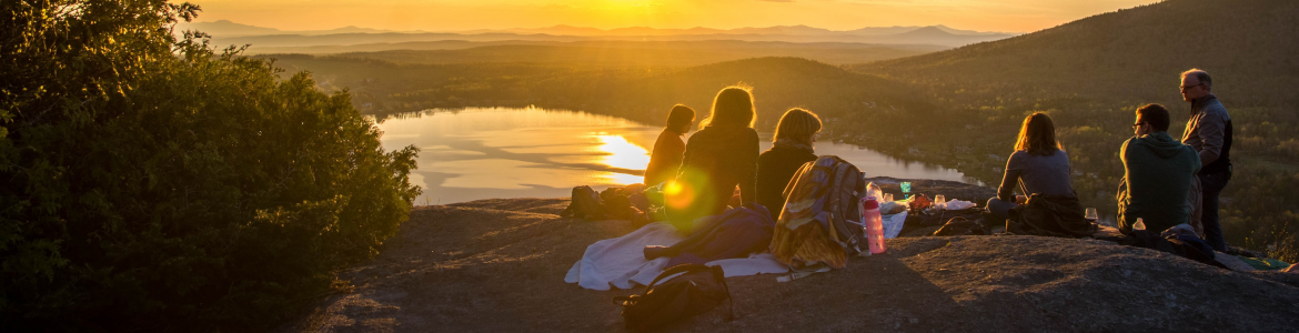 Un grupo de personas viendo el atardecer en un acantilado