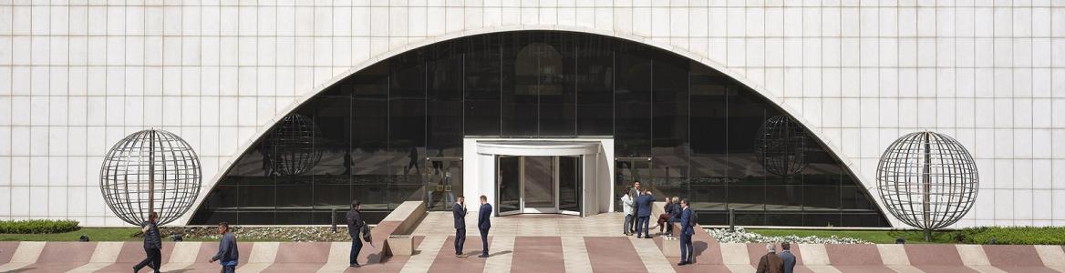 Distrito Tetuán. Torre Picasso. Fernando Maquieira Varias personas andando en una plaza, se aprecia la entrada y parte inferior del edificio Torre Picasso