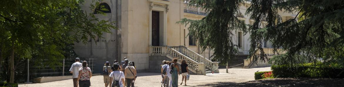 palacio y grupo de gente paseando en los jardines