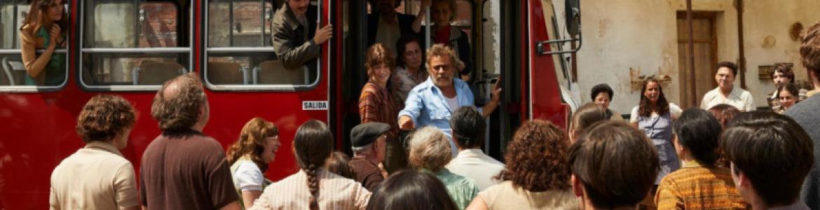fotograma de un autobús rodeado de personas 