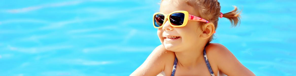 Niña sonriente en el borde de la piscina