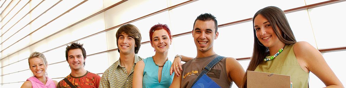 Seis estudiantes de pie posan sonrientes