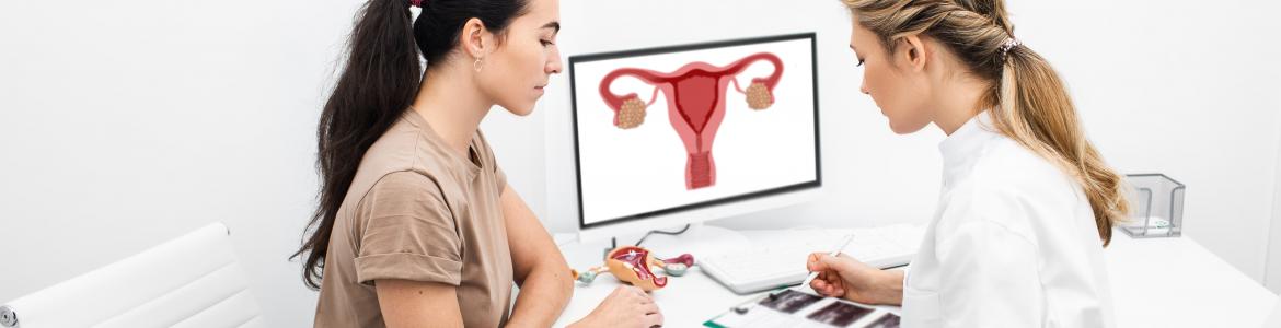 Mujer joven visitando a la ginecóloga que le explica sentadas con un papel