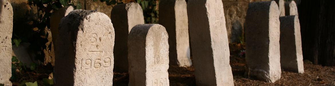 Lápidas de cementerio Lápidas sencillas frente a la pared de un cementerio