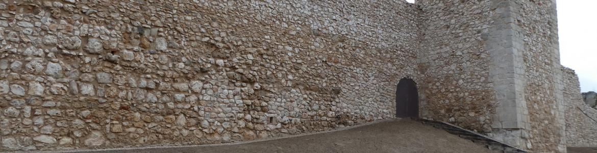 Castilla de Santorcaz tras la restauración muralla de piedra con torre rectangular y puerta de acceso