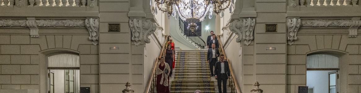 escalinata de palacio por la que bajan un grupo de personas 