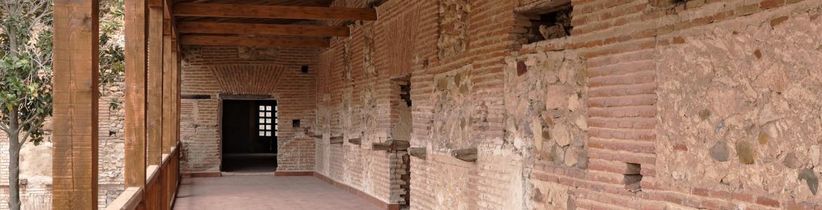 Galería de la cartuja tras la intervención galería con techo y balcón de madera, pared de mampostería y dos accesos