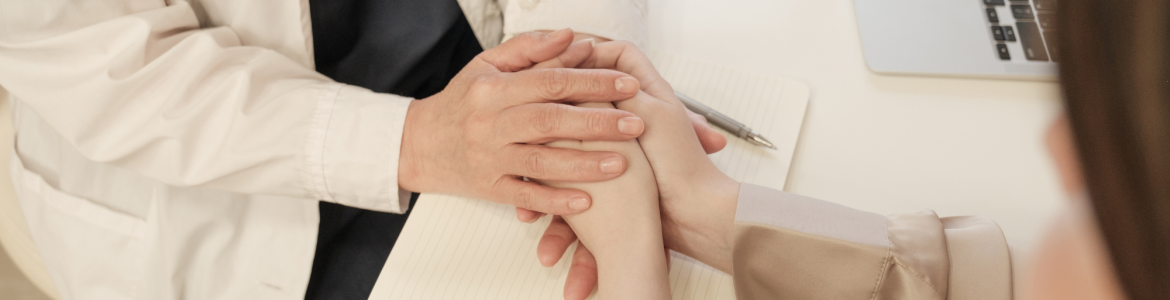 médico sosteniendo las manos de paciente