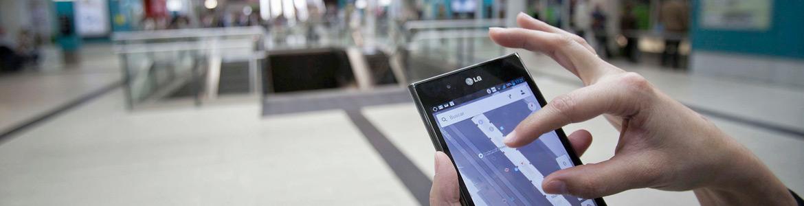 Apps transporte público Mano sosteniendo un móvil y ampliando la imagen de la pantalla