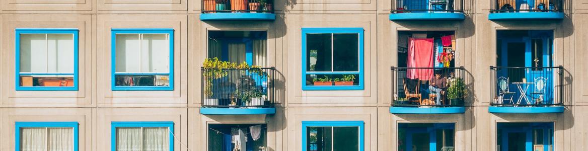 Fachada de un bloque de viviendas con ventanas azules