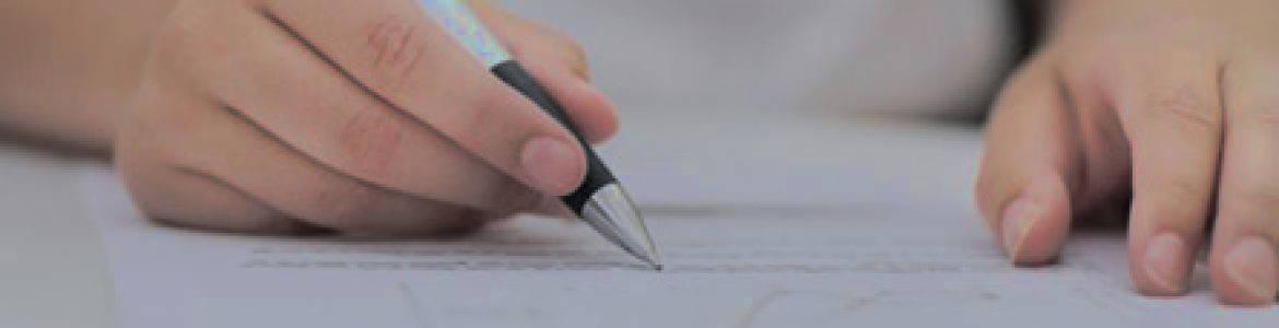 Criterios comunes a todos los permisos y licencias Mano firmando documento con boli