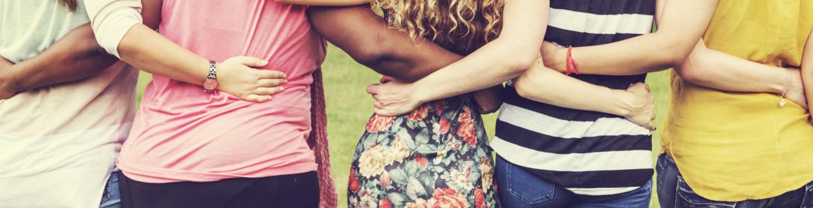 Alojaremos y atenderemos a mujeres reclusas y ex reclusas para facilitar su reinserción social Varias mujeres de espaldas en línea abrazadas por la cintura