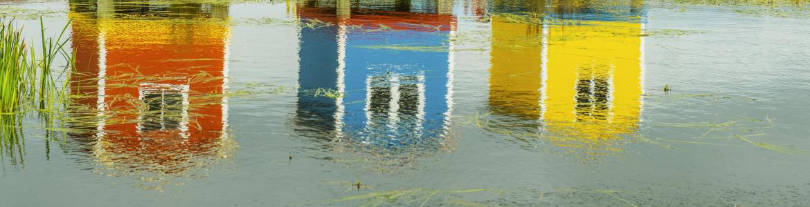 Casetas de madera de colores con reflejos en el agua