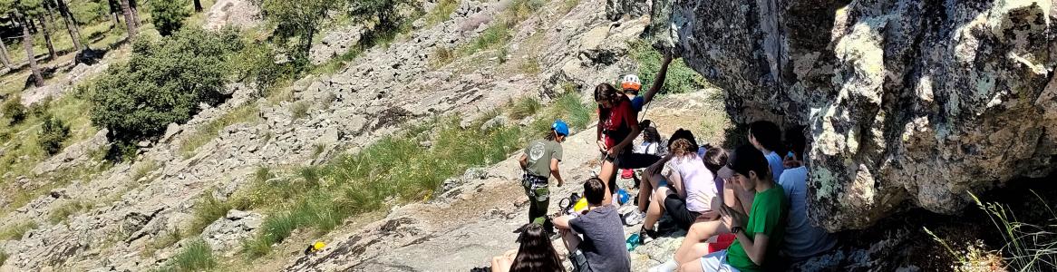 Jóvenes sentados preparados para escalar pared de piedra