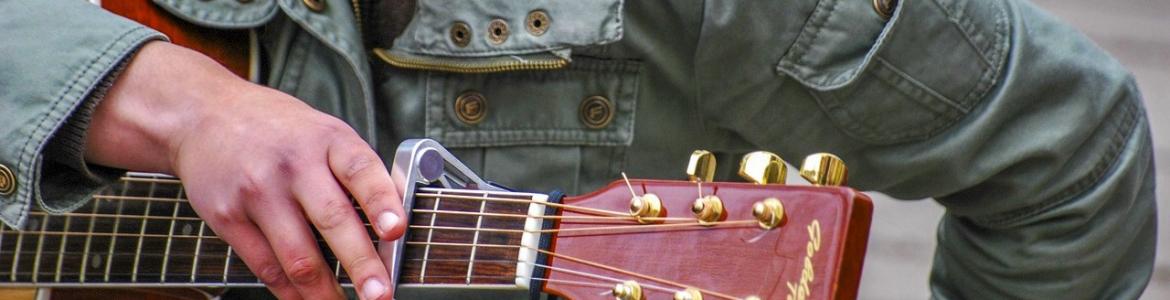 Mujer con la mano puesta en una guitarra