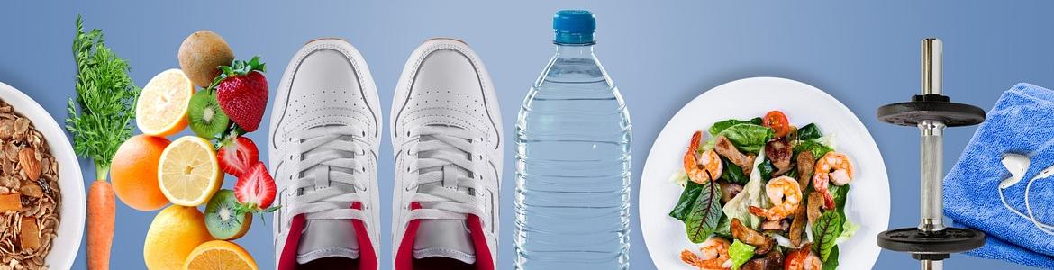 Plato con cereales, frutas, zapatillas de deporte, botella de agua, mancuernas, bol de ensalada y una toalla con auriculares