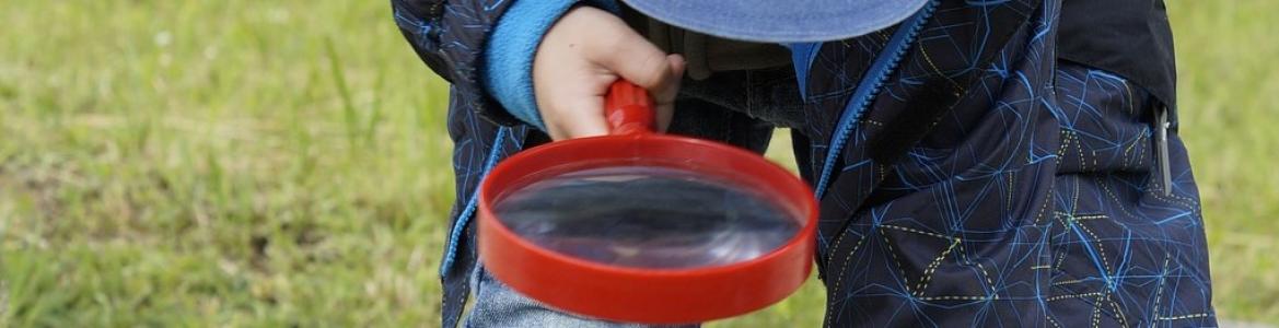 Niño con lupa en huerto