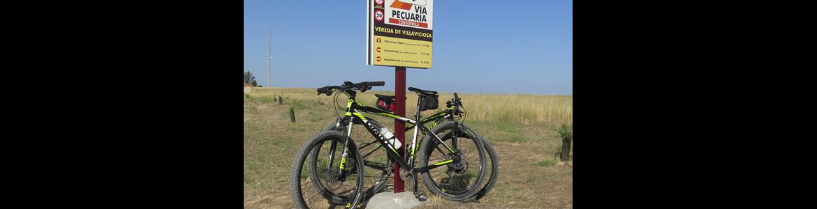 Bicicleta apoyada en el cartel de inicio de la vía pecuaria "Vereda de Villaviciosa"