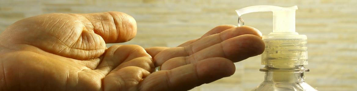 mano de hombre abierta para recoger una gota de gel de un dispensador
