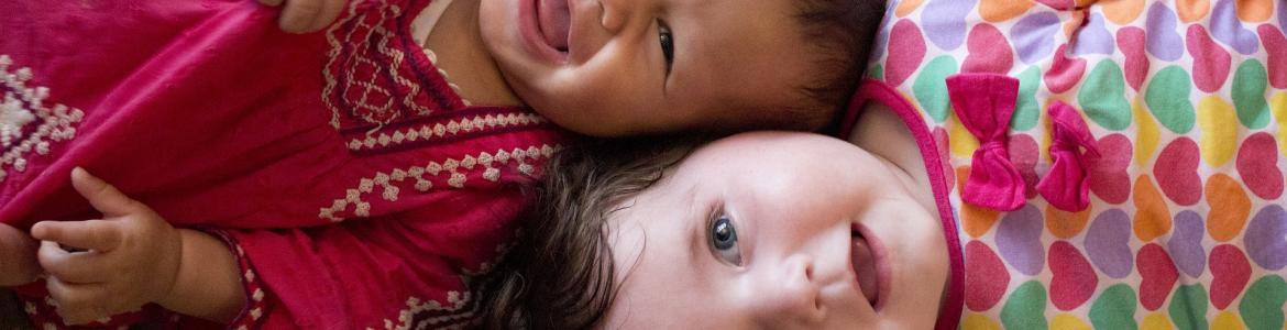 niños sonriendo sobre una cama