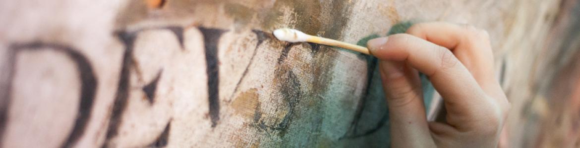 Detalle de mano restaurando una pintura Detalle de mano restaurando una pintura