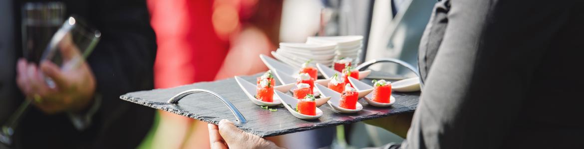Camarero sirviendo canapés en evento al aire libre