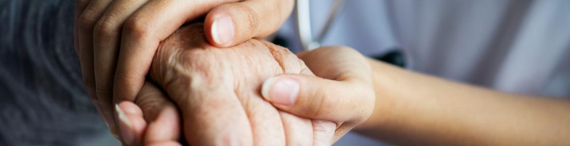 atención a las personas mayores Un sanitario coge las manos de una persona mayor