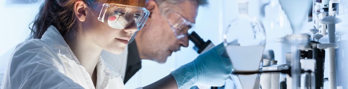Mujer y hombre científicos trabajando en laboratorio con microscopio y material de ensayos y 