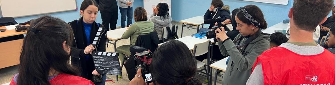 Jóvenes en un aula con cámaras fotográficas enfocando