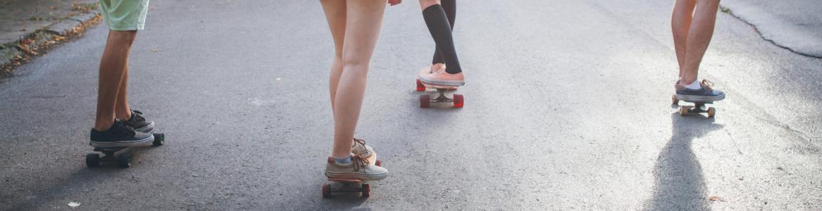 Jóvenes en patinete por una calle