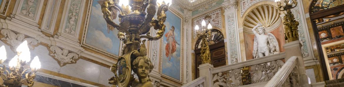 escalera interior palacio con lámpara en primer plano