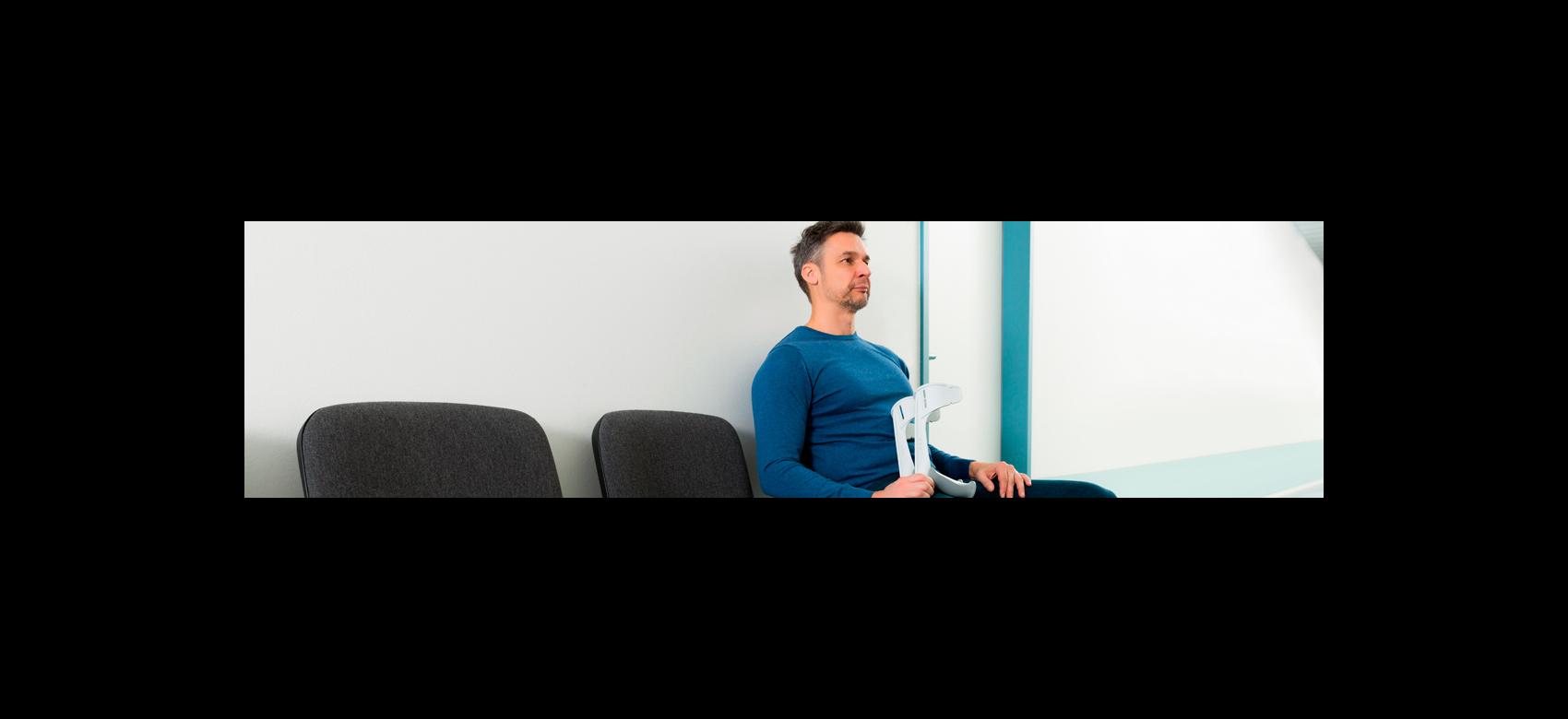 Imagen ilustrativa de un hombre con muletas en una sala de espera