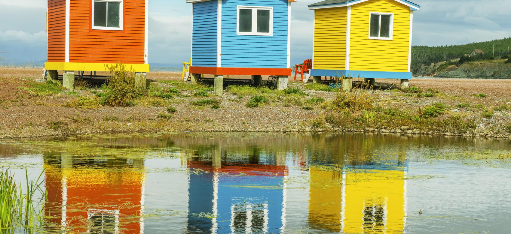 Casetas de madera de colores con reflejos en el agua
