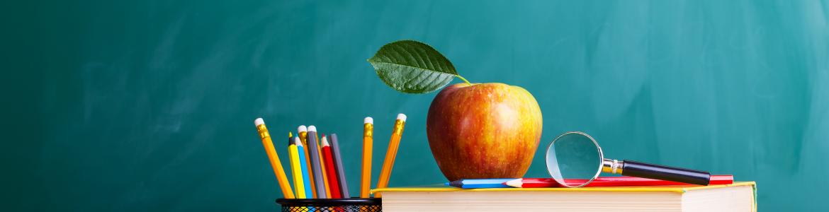 Educación Libros, lapiceros y una manzana