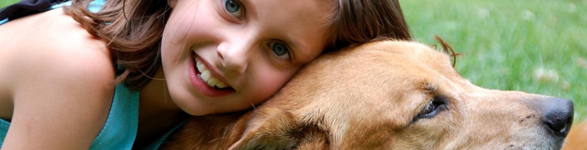 Zoonosis - Niña y perro Niña abrazando a un perro en un parque